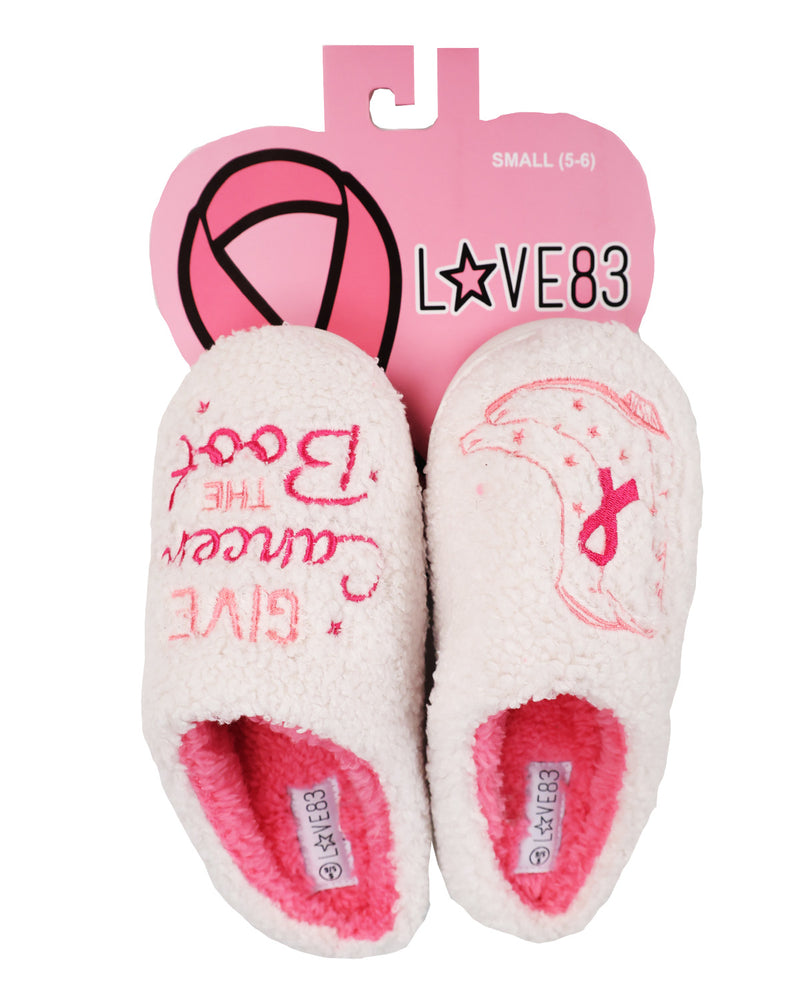 A pair of white sherpa slippers with pink lining and pink printed designs, attached to a pink retail hanger card. The left slipper reads 'The Book Cancer Give' and has a pink shoe print, while the right slipper has a pink ribbon and star print.