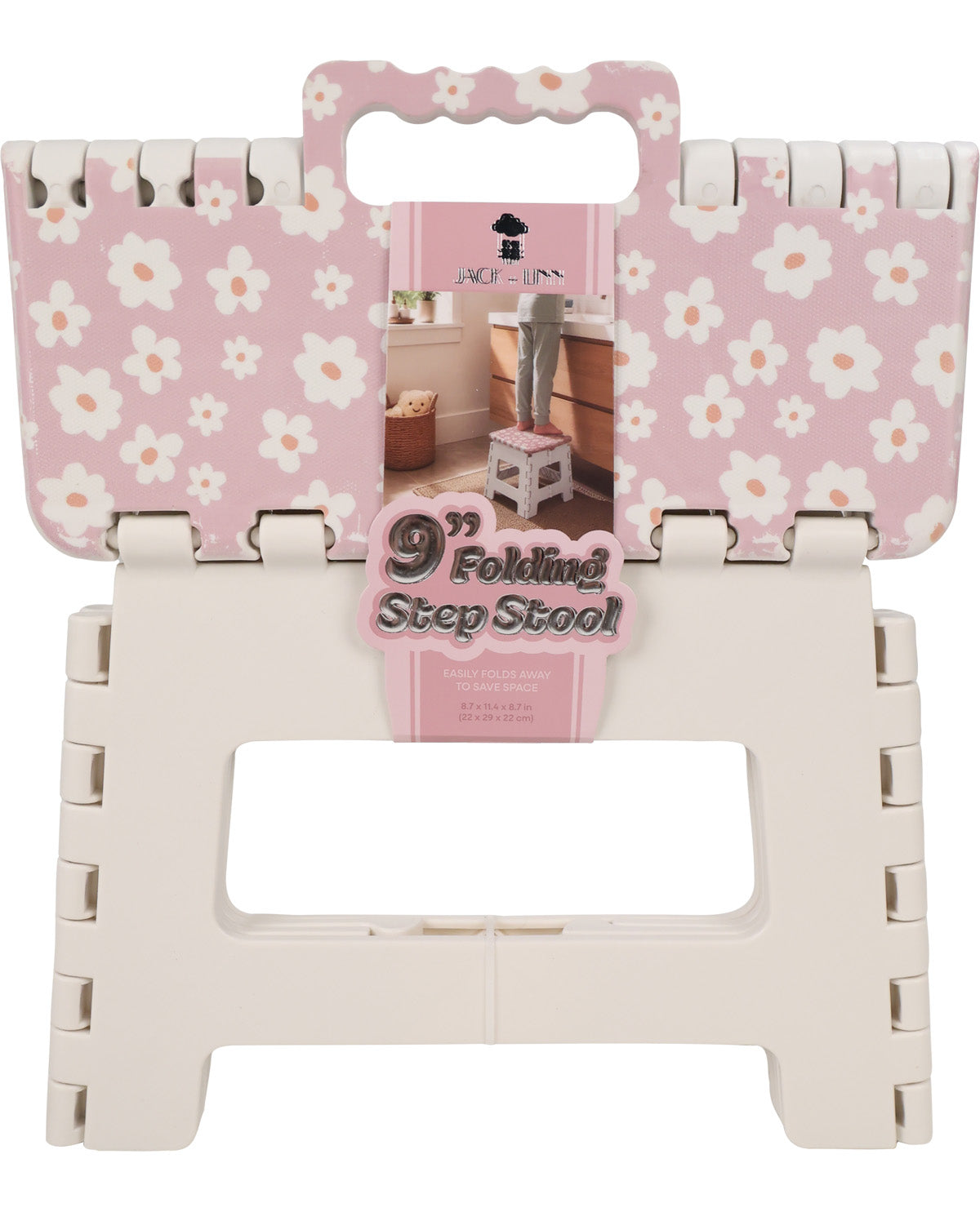 A 9-inch folding step stool shown folded flat with its pink floral retail packaging attached. The top panel has a pink background with a white daisy floral pattern, and the lower folded frame is off-white plastic.