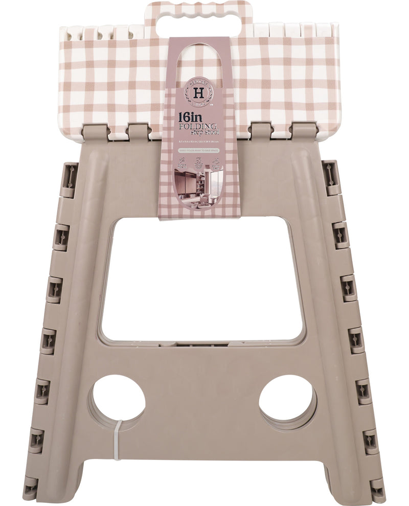 A 16-inch folding step stool with a beige plastic frame and a light pink and white gingham fabric top, shown with its retail hangtag against a white background.