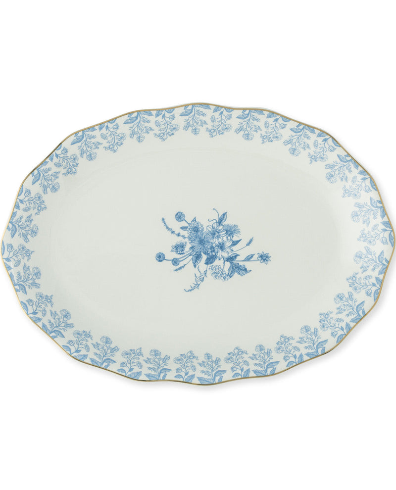 An oval ceramic serving platter with a scalloped edge, featuring a delicate blue floral toile pattern around the border and a matching floral motif in the center, set against a plain white background.