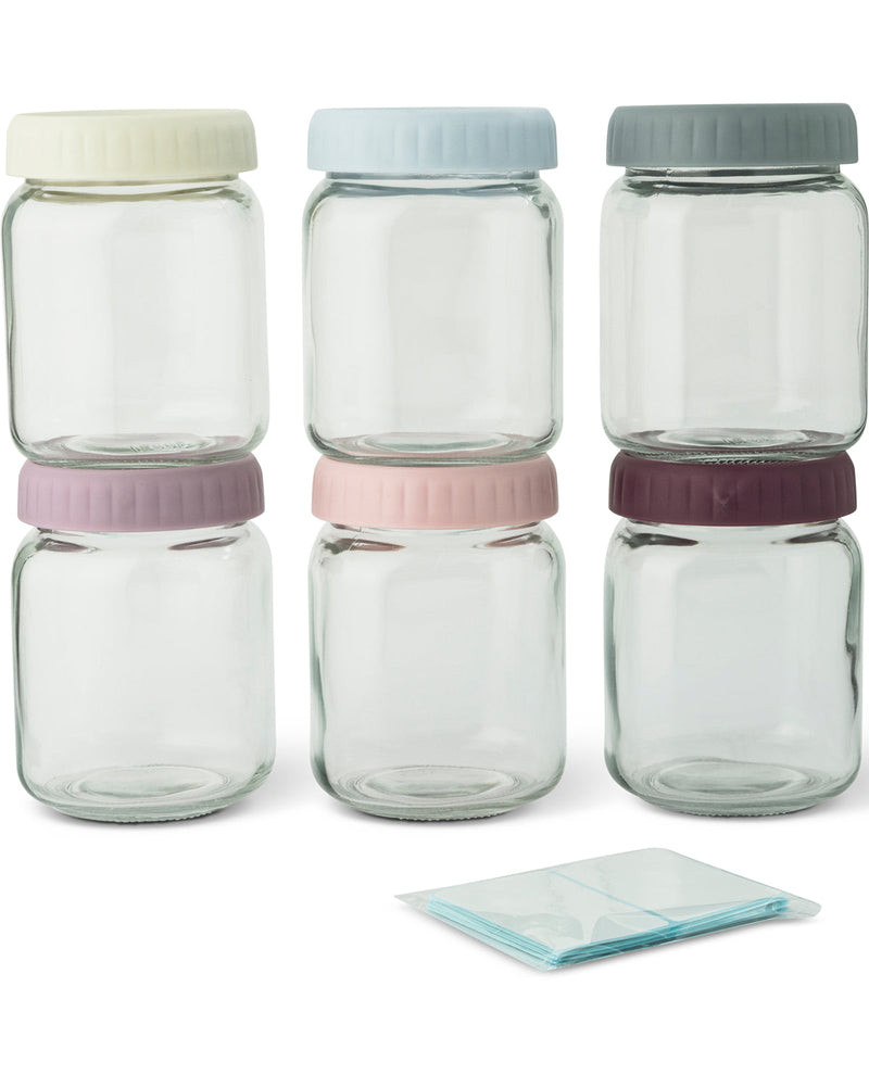 Six clear glass storage jars with screw-top lids in assorted pastel and neutral colors, arranged in two rows on a white background, with a small folded translucent pouch placed in front.