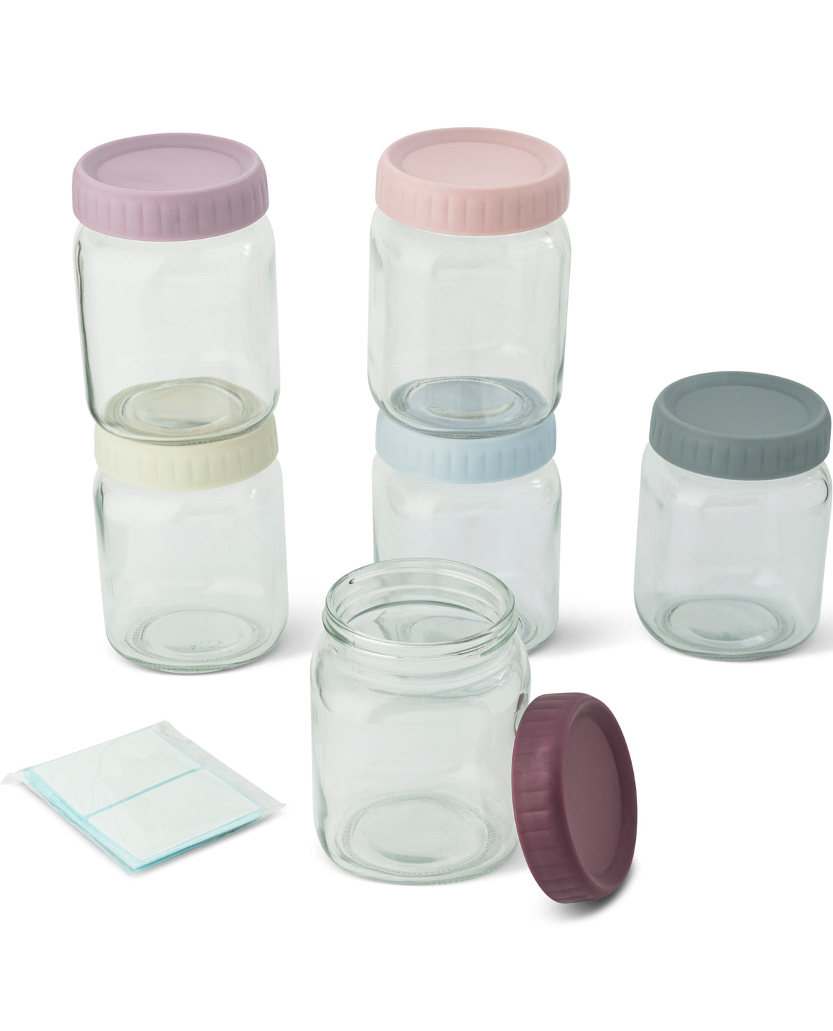 A set of clear glass storage jars with pastel-colored screw-on lids in lavender, blush pink, pale blue, gray, and dark plum, shown on a clean white background with a small packet of contents.