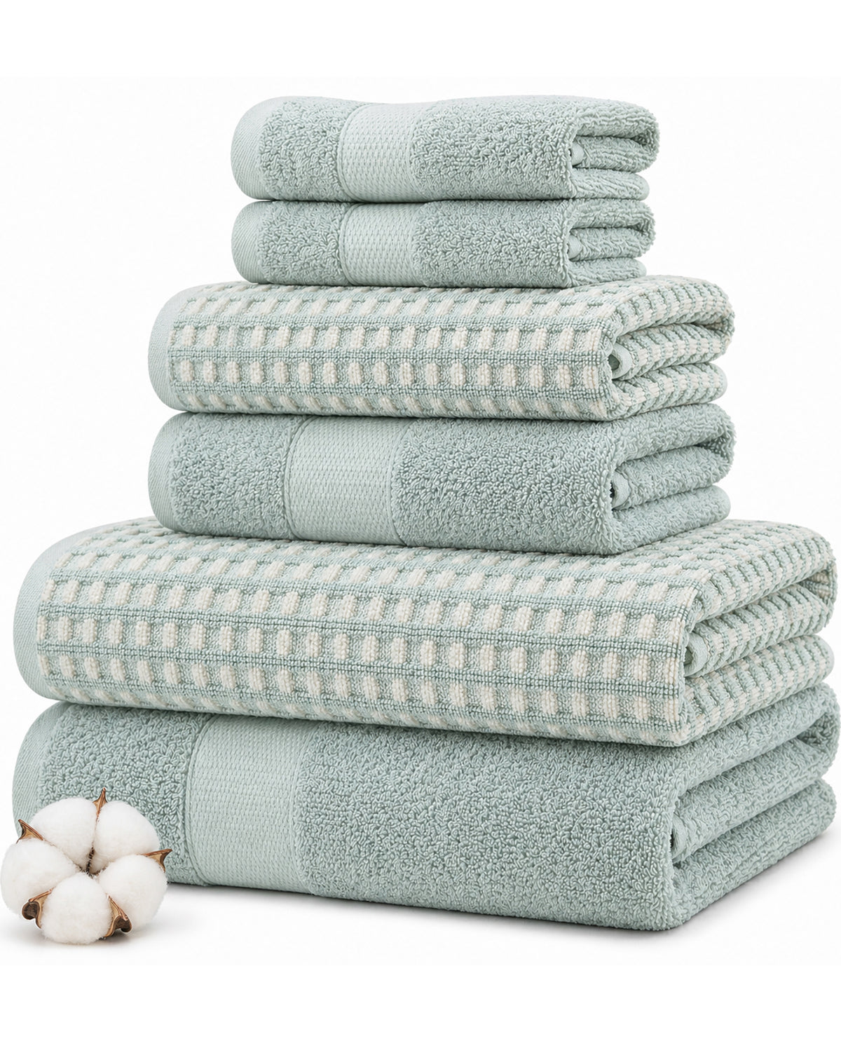 A set of folded bath towels in a pale sage green and white waffle-weave pattern, stacked neatly on a white background with a small cotton boll prop in the lower left corner.