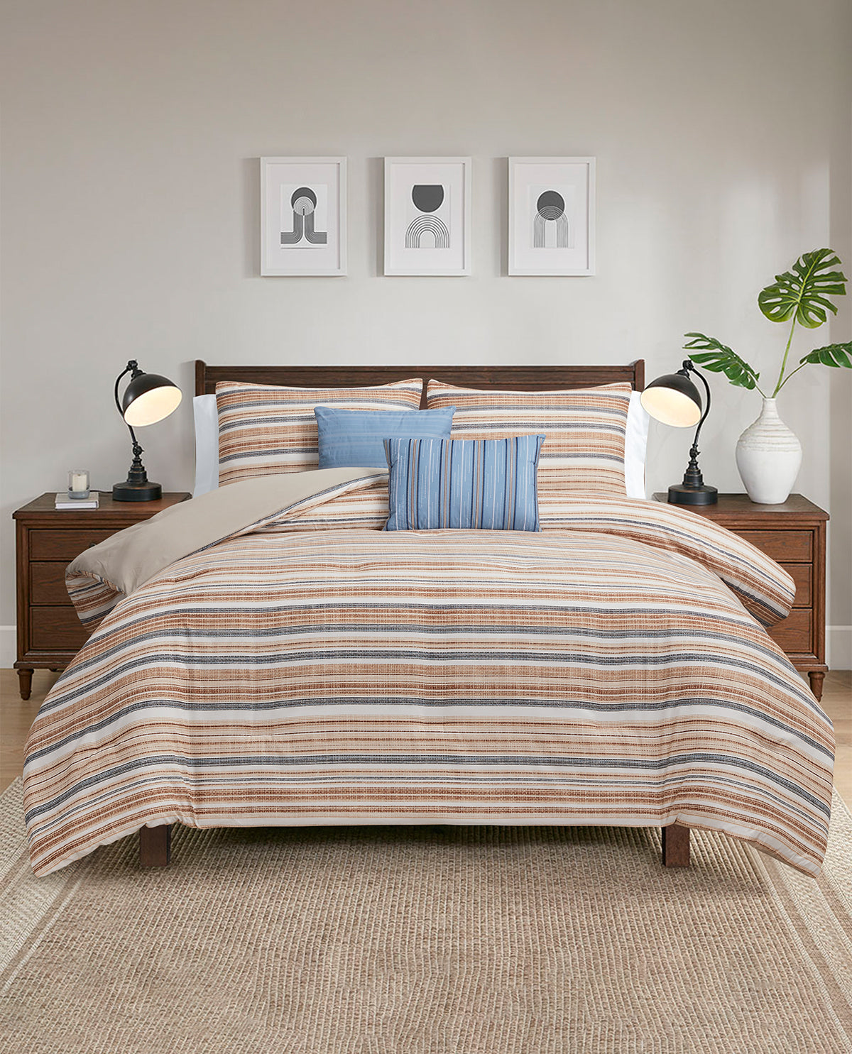 A bed dressed in a striped bedding set with beige, brown, and blue tones, styled in a modern bedroom with wooden nightstands, black lamps, framed wall art, and a potted plant.