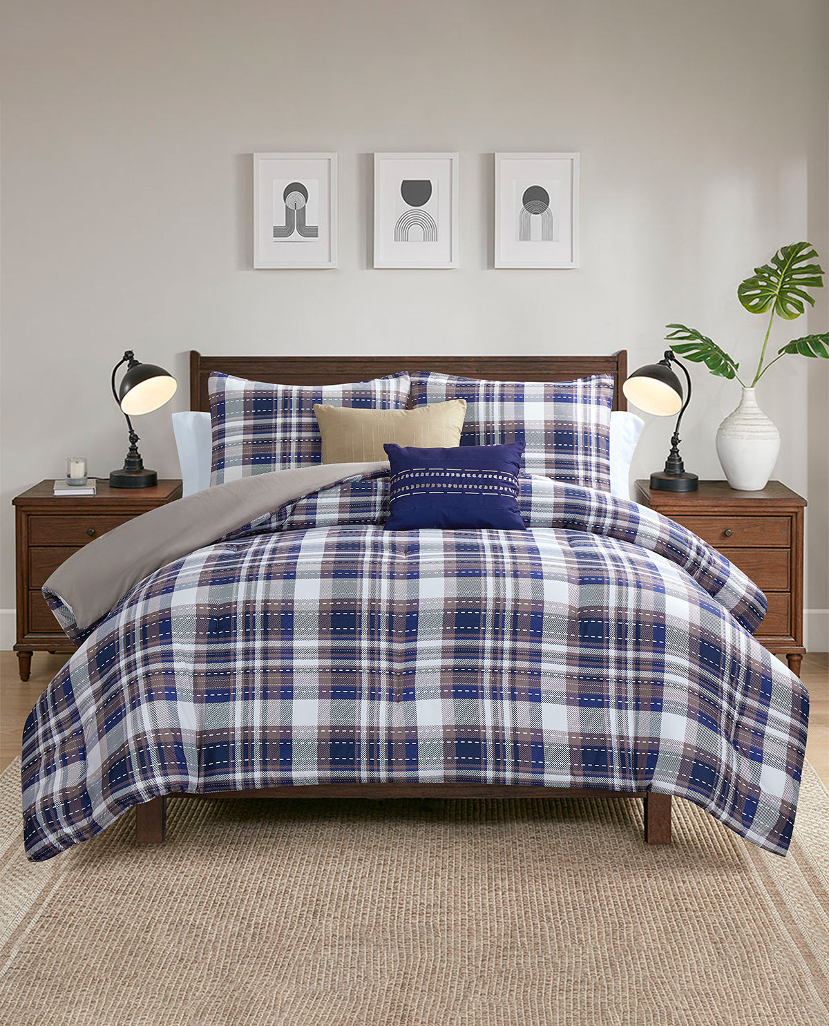 A bed dressed in a blue, white, and beige plaid comforter set with matching pillows, styled in a modern bedroom with wooden nightstands, lamps, and wall art.