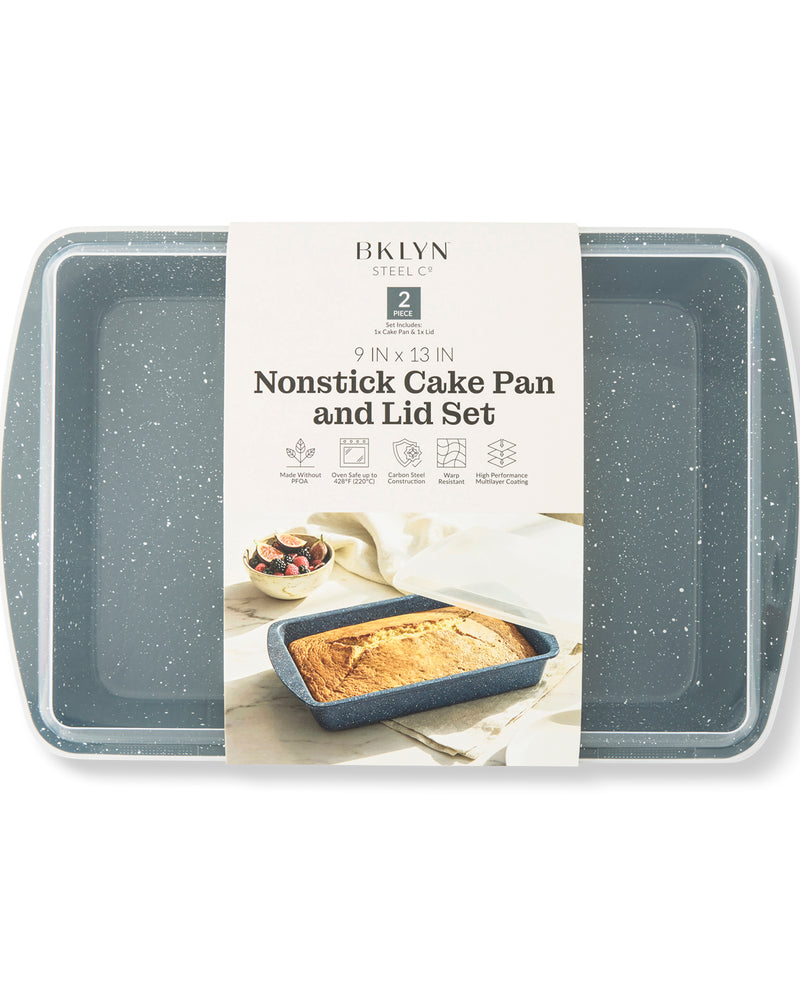 A 9x13-inch nonstick cake pan and lid set by Brooklyn Steel, featuring a speckled dark gray exterior and a cream-colored paper label wrapped around the center, displayed on a clean white background.