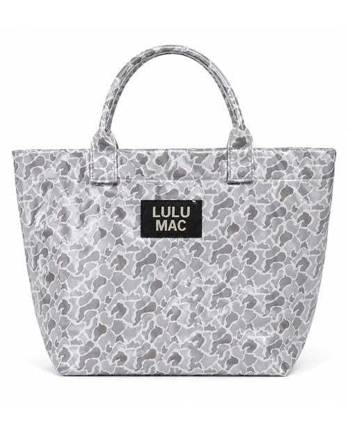 A gray and white camouflage tote bag with a black rectangular patch on the front that reads 'LULU MAC' in white text, set against a plain white background.