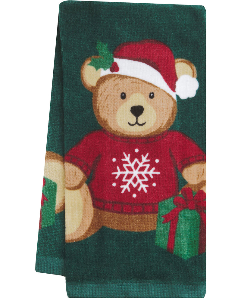 A dark green towel featuring a teddy bear wearing a red Santa hat and red sweater with a white snowflake, holding a green gift box.