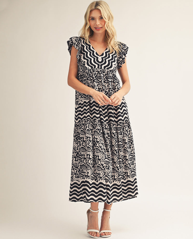 Woman wearing a black and white patterned dress on a beige background