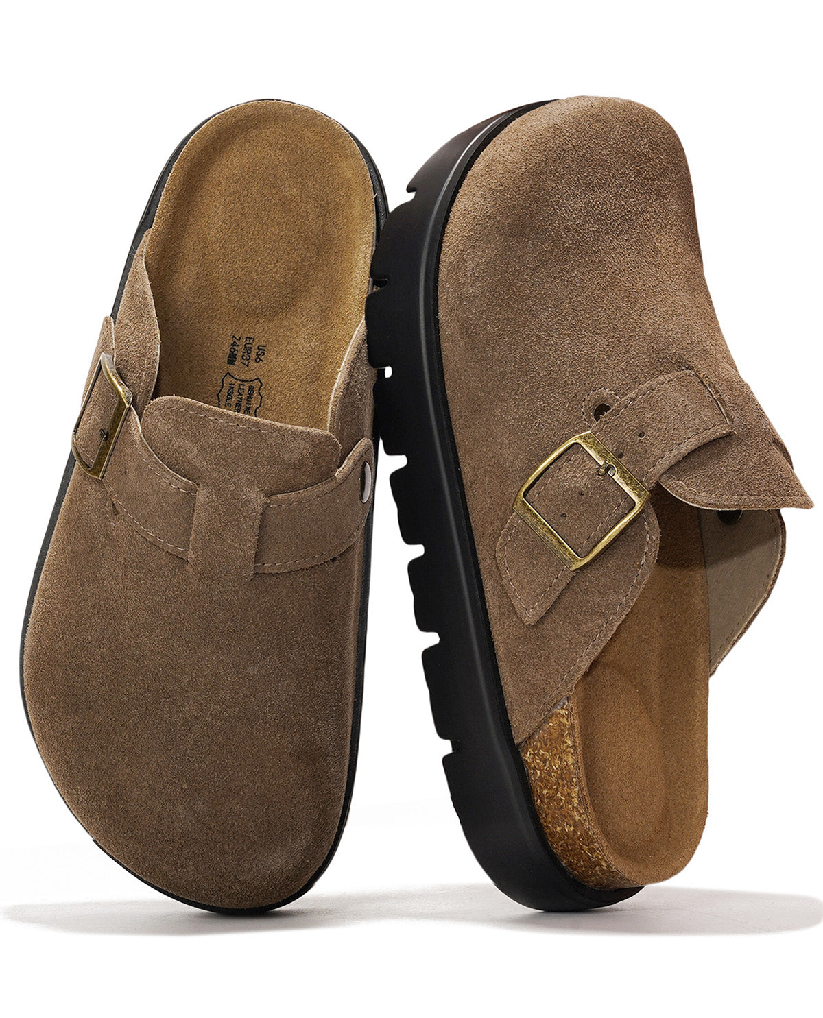 A pair of brown suede clogs with gold-tone buckle straps and black lug soles, shown from the side and top on a white background.