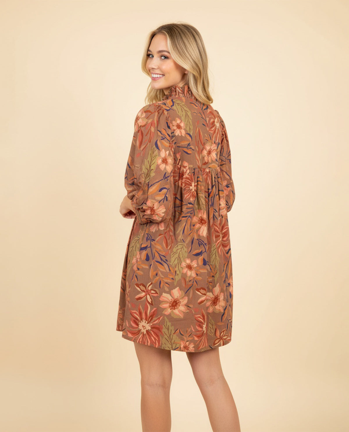 Woman wearing a floral dress on a beige background