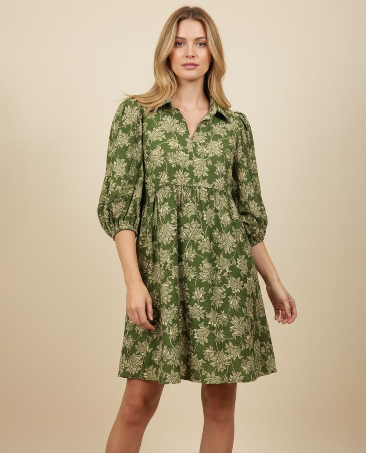 Woman wearing a green floral dress against a beige background
