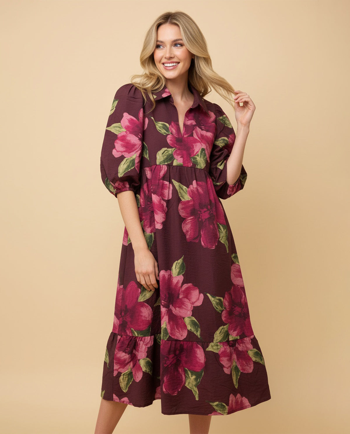 Woman wearing a burgundy floral dress against a beige background