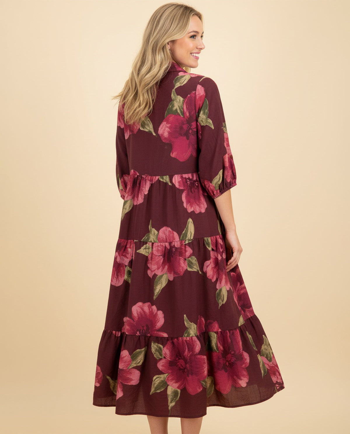 Woman wearing a burgundy floral dress on a beige background