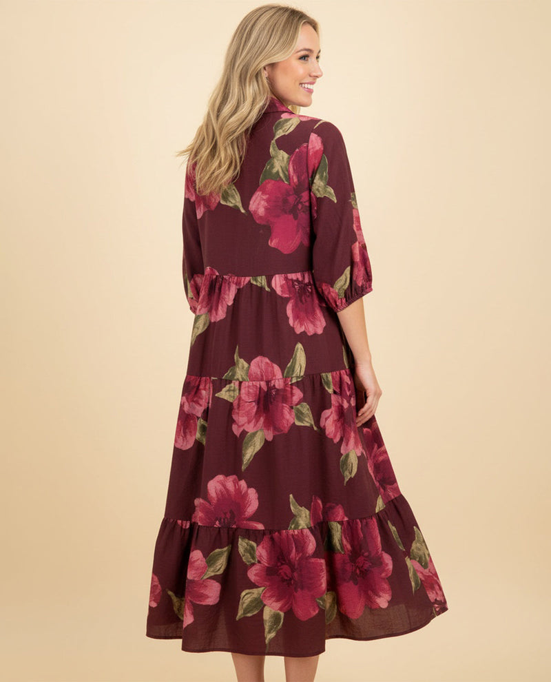 Woman wearing a burgundy floral dress on a beige background