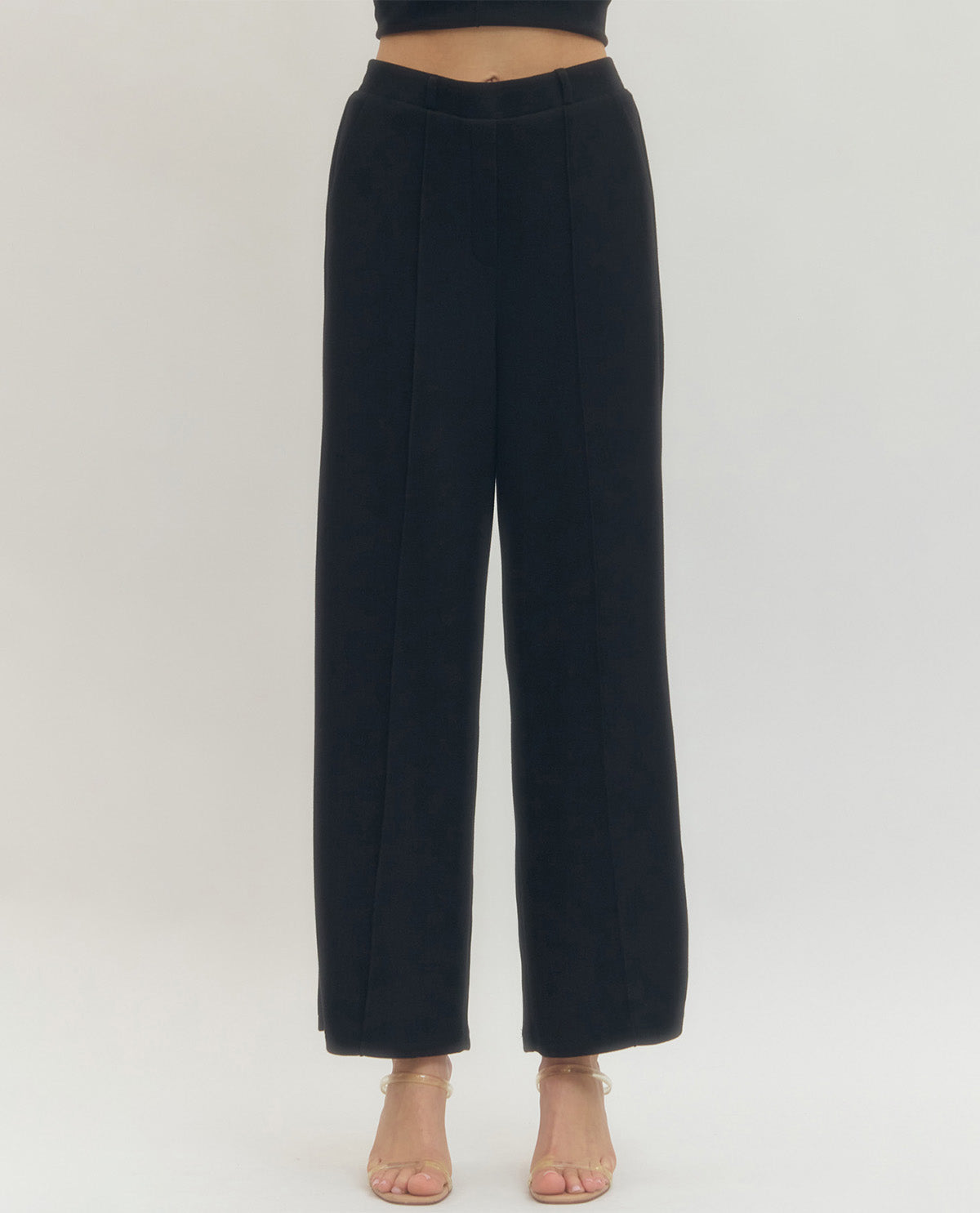 Black wide-leg pants worn by a person on a white background