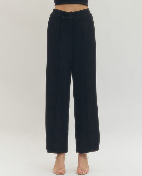 Black wide-leg pants worn by a person on a white background