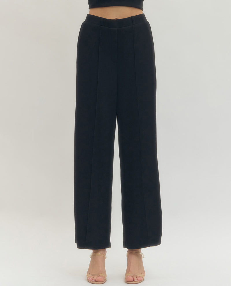Black wide-leg pants worn by a person on a white background