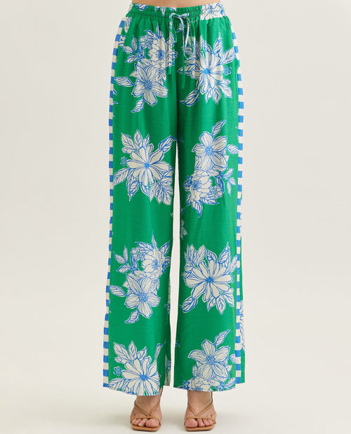 Green floral-patterned pants with blue accents on a white background