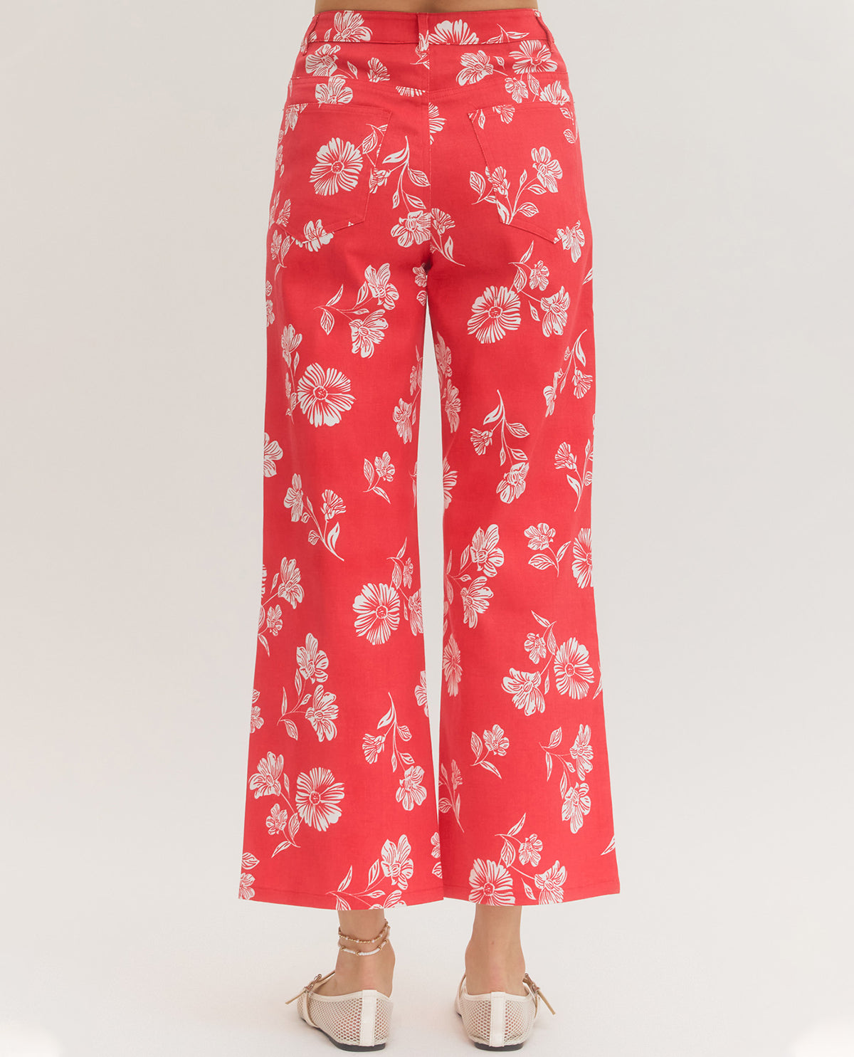 Red pants with white floral pattern on a white background