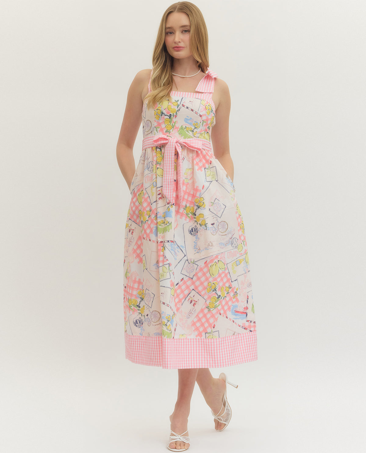 Woman wearing a patterned dress with a pink bow on a white background