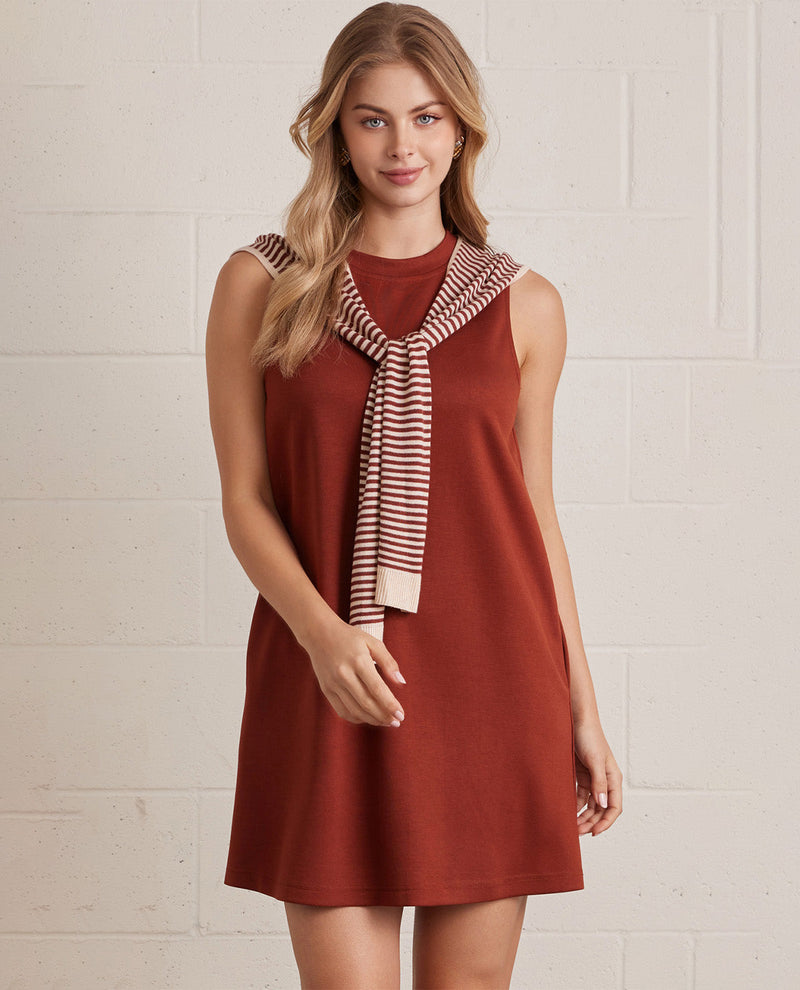 Woman wearing a red dress with a striped scarf against a light background