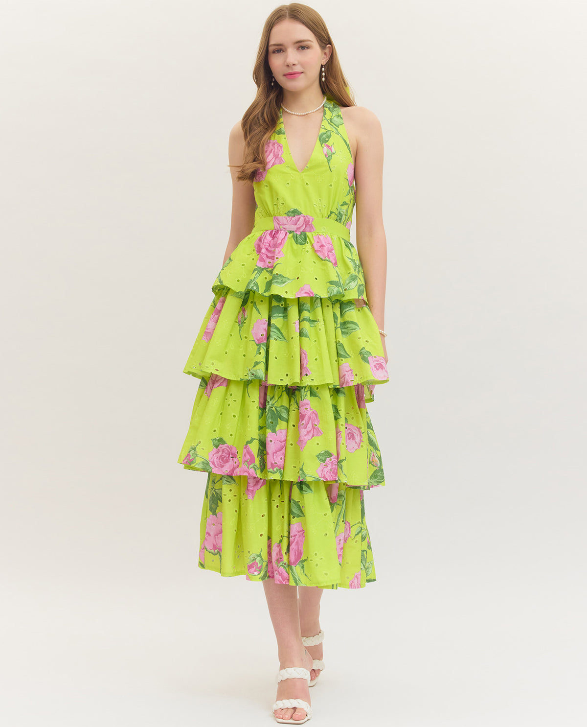 Woman wearing a green floral dress on a white background