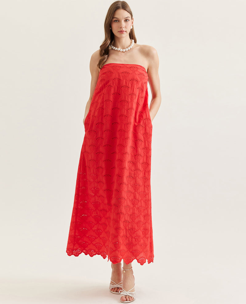 Woman wearing a red strapless dress on a white background