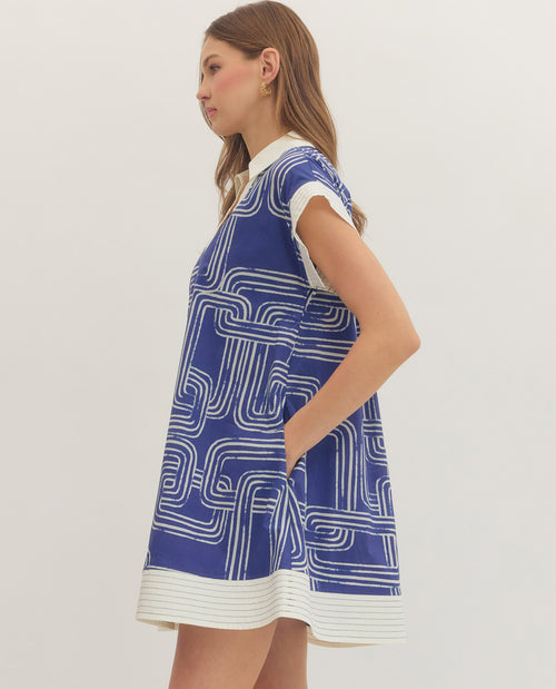 Woman wearing a blue and white patterned dress on a plain background