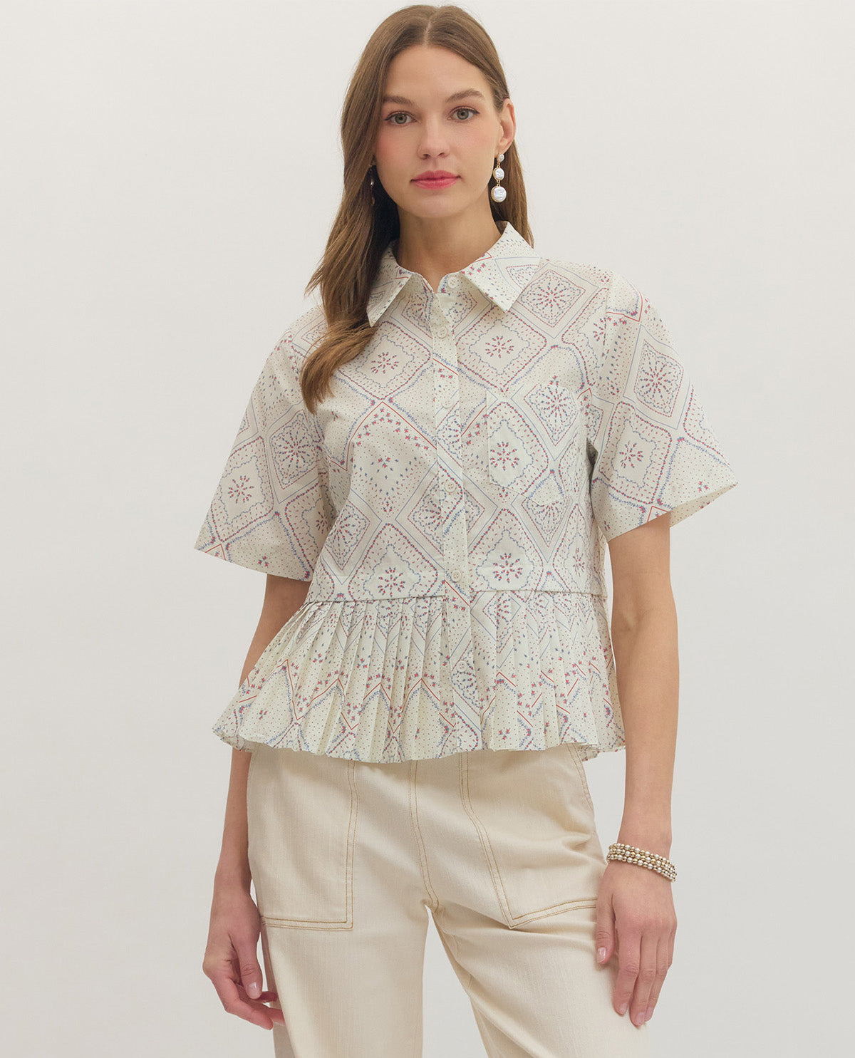 Woman wearing a patterned blouse with a plain background