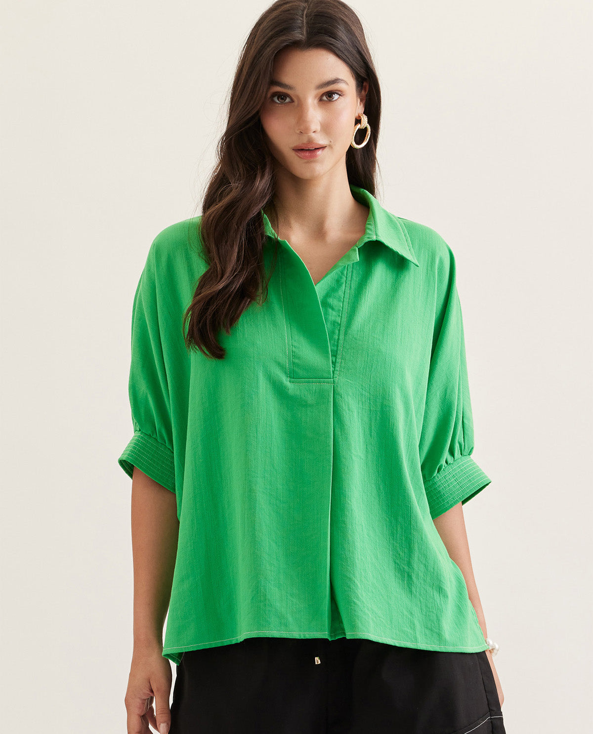 Woman wearing a green shirt against a plain background