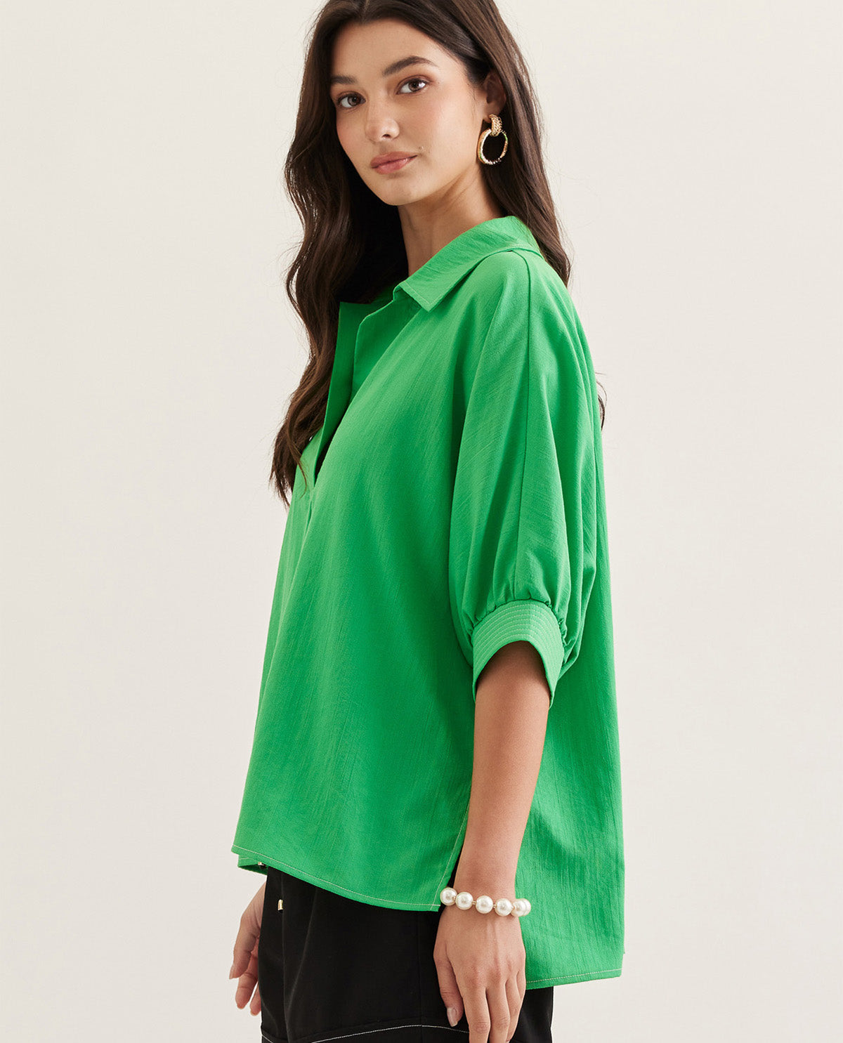 Woman wearing a green shirt on a plain background