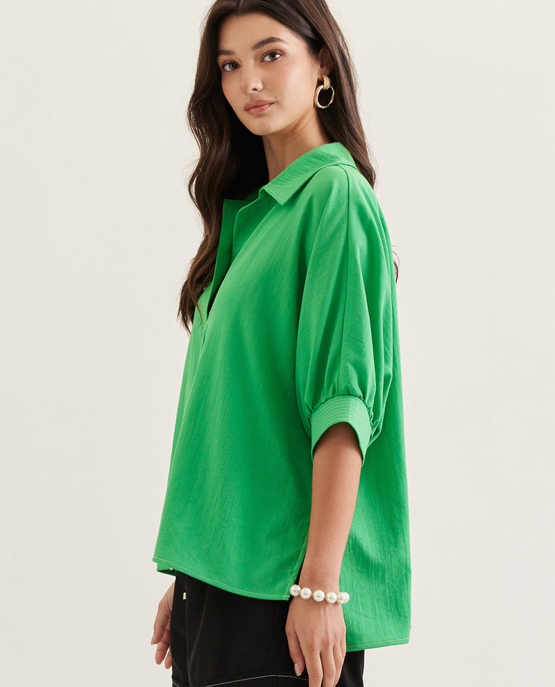 Woman wearing a green shirt on a plain background