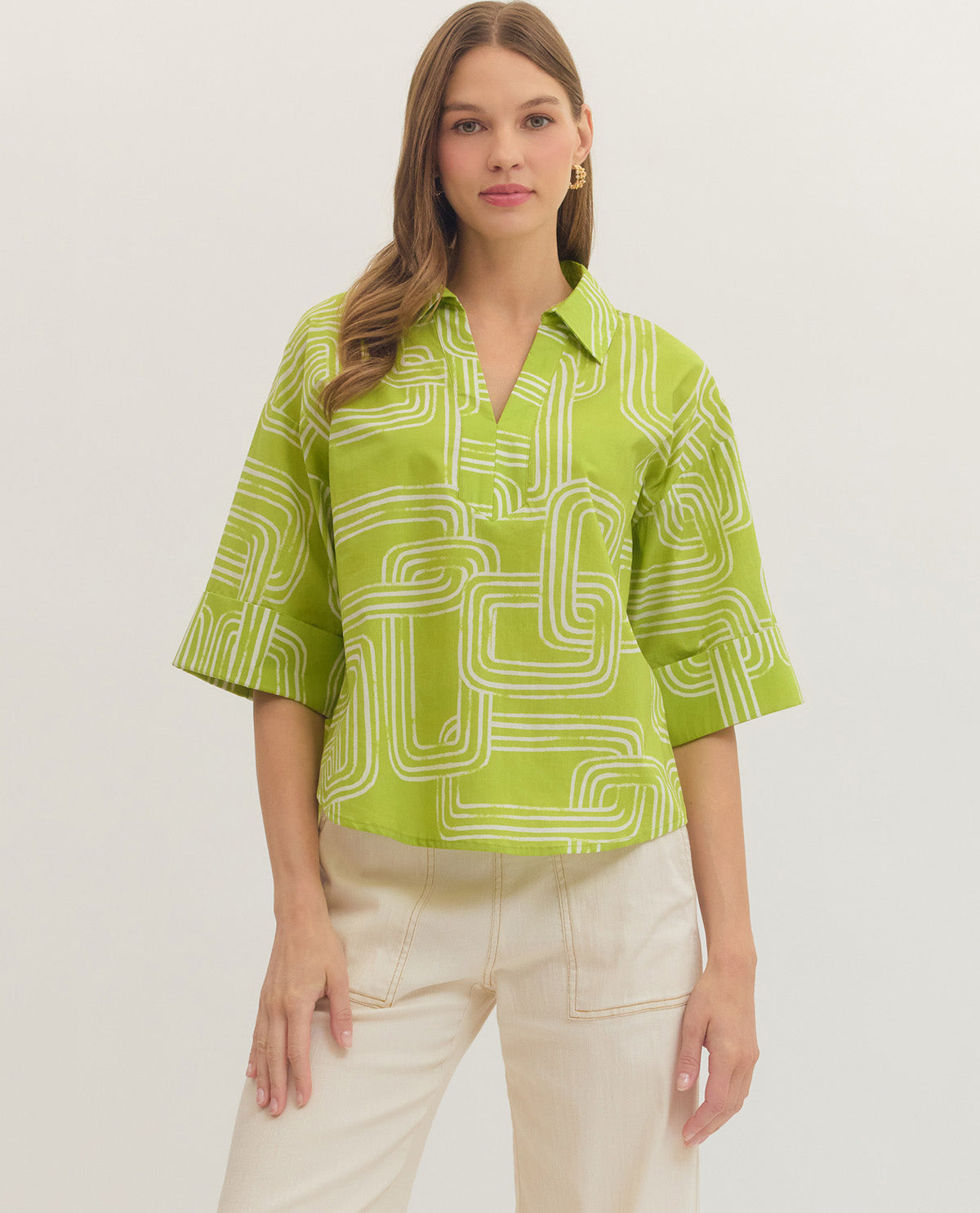 Woman wearing a green patterned shirt against a white background