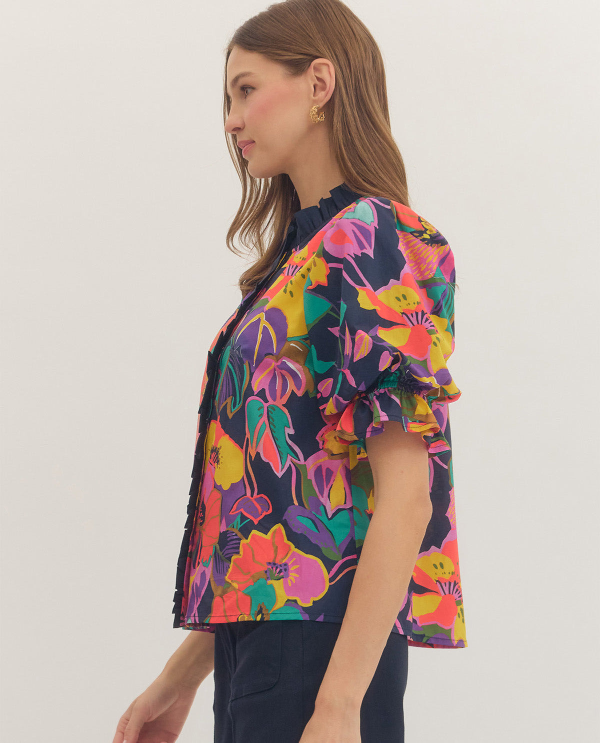 Woman wearing a colorful floral patterned shirt on a white background