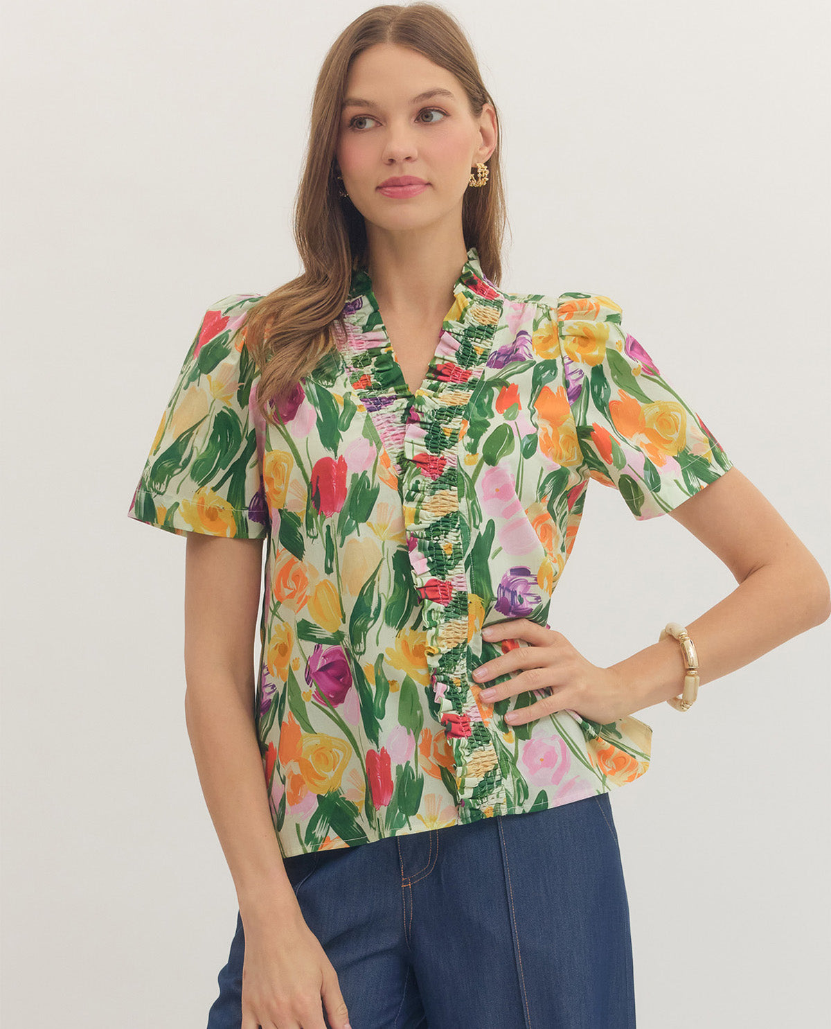 Woman wearing a colorful floral blouse against a white background