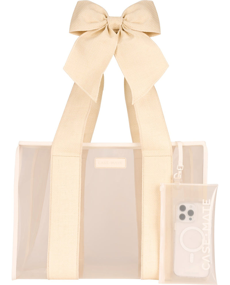 A clear plastic tote bag with cream-colored fabric handles and a matching cream ribbon bow at the top, shown on a white background. A matching clear phone case with a MagSafe ring is attached to the side.
