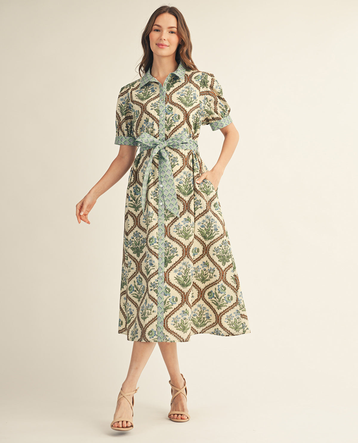 Woman wearing a patterned dress on a plain background