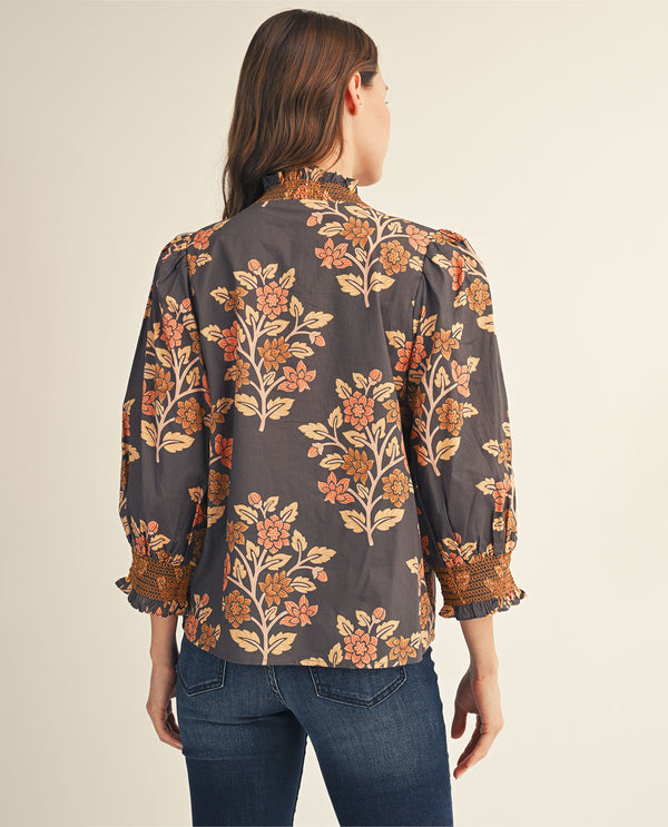 Woman wearing a floral blouse with a neutral background
