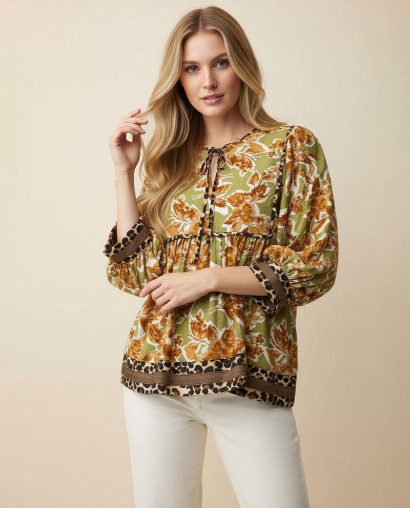 Woman wearing a patterned blouse with a beige background