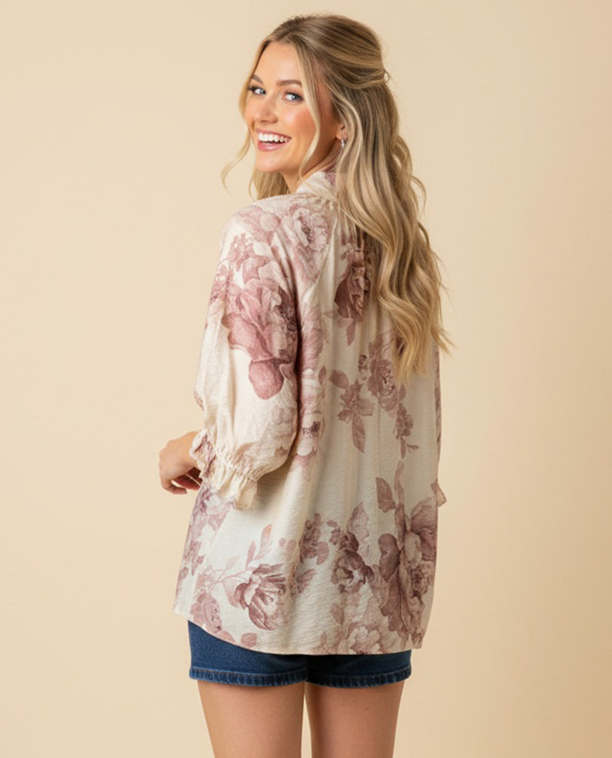 Woman wearing a floral blouse with a beige background