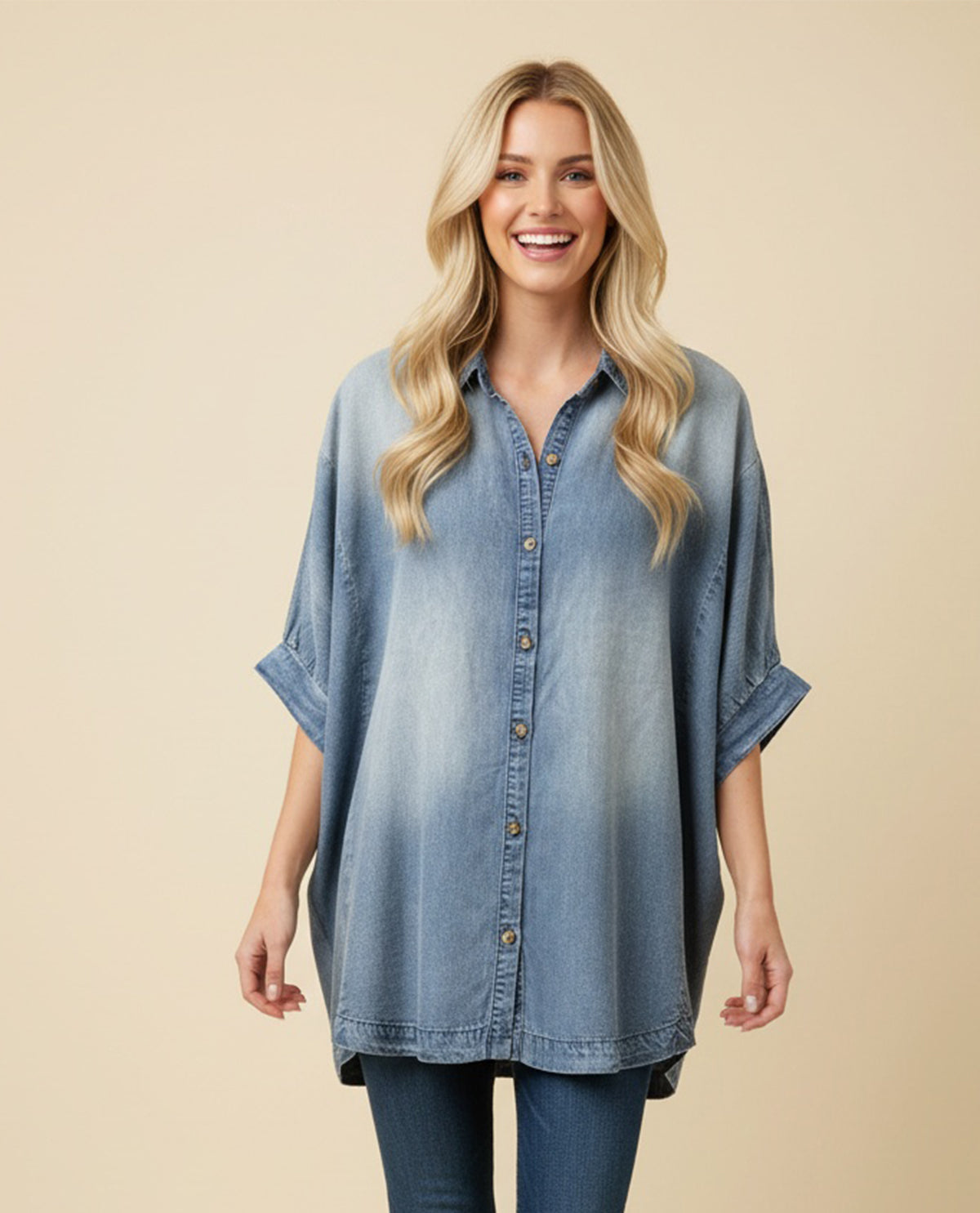 Woman wearing a blue denim shirt against a beige background