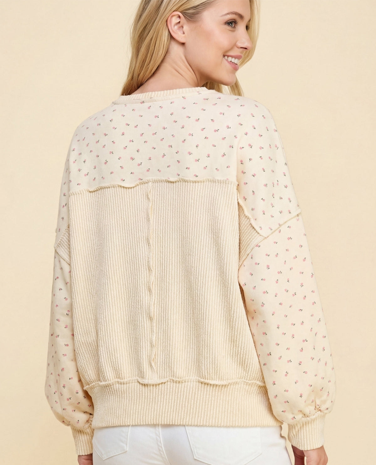 Woman wearing a beige sheer blouse with a plain background
