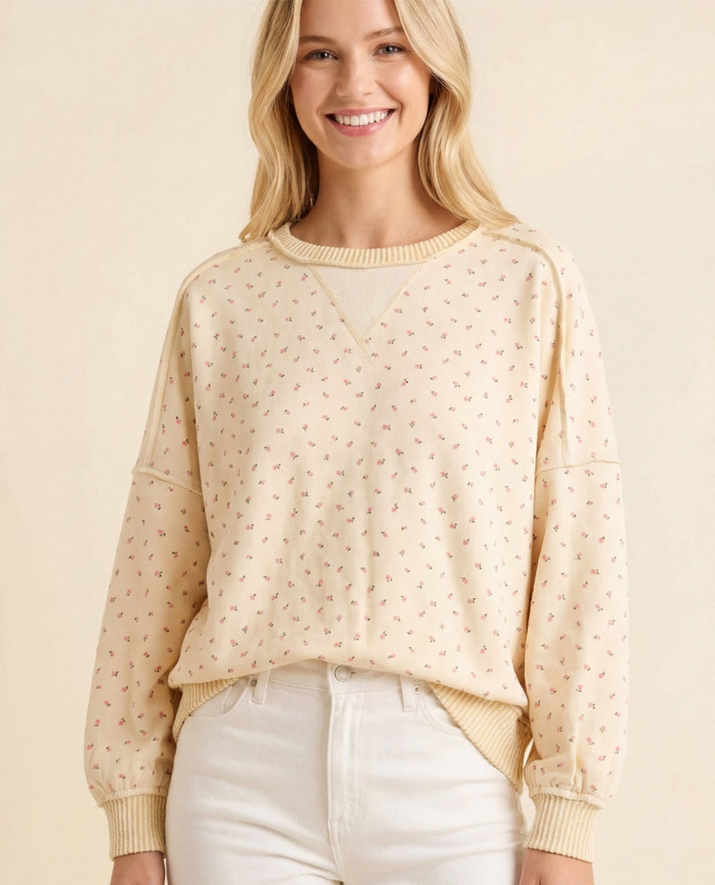 Woman wearing a beige sweater with a subtle pattern on a beige background