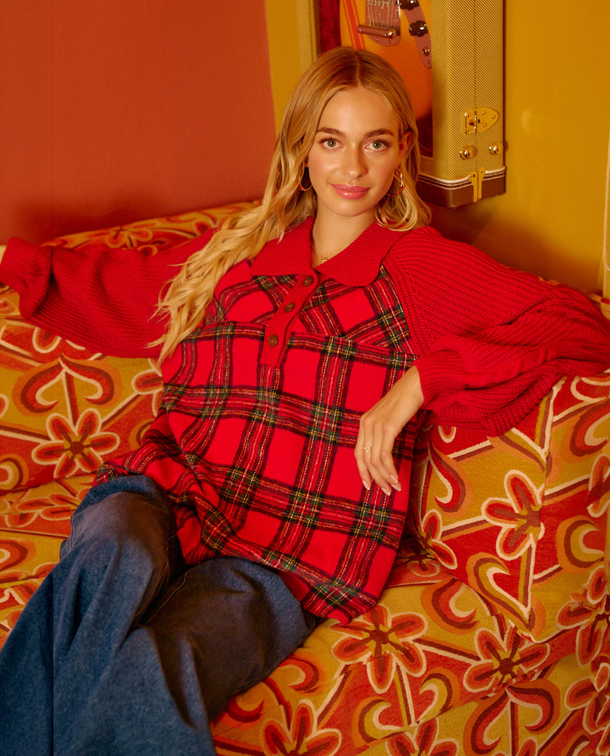 Missy model wearing a long sleeve red plaid top sitting on a couch