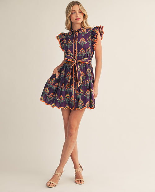 Woman wearing a patterned dress on a plain background