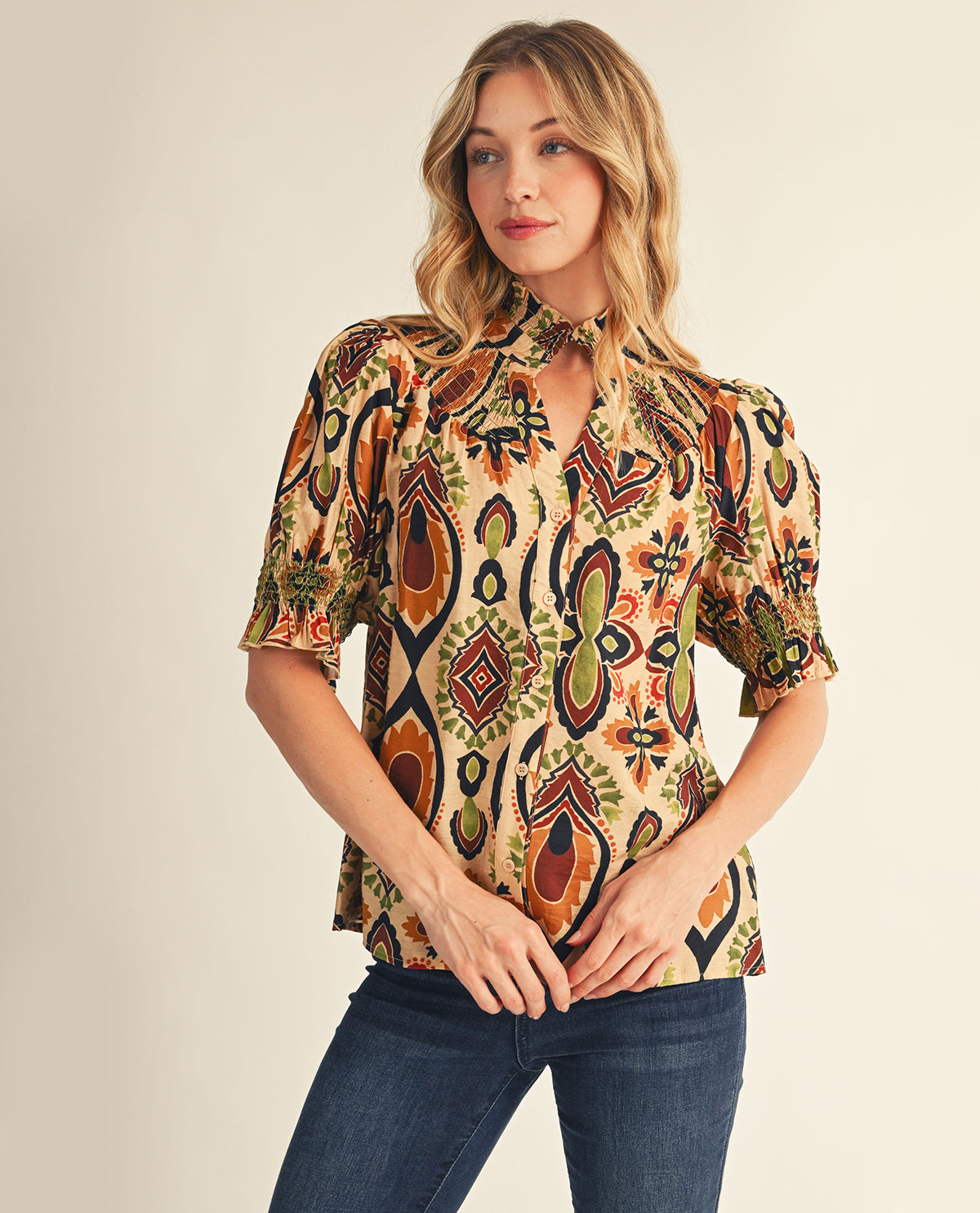 Woman wearing a patterned blouse with a neutral background