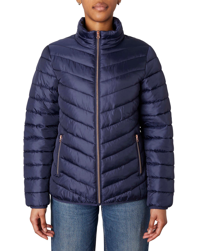 A navy blue puffer jacket with a high collar and vertical quilting, shown on a model wearing blue jeans against a plain white background.