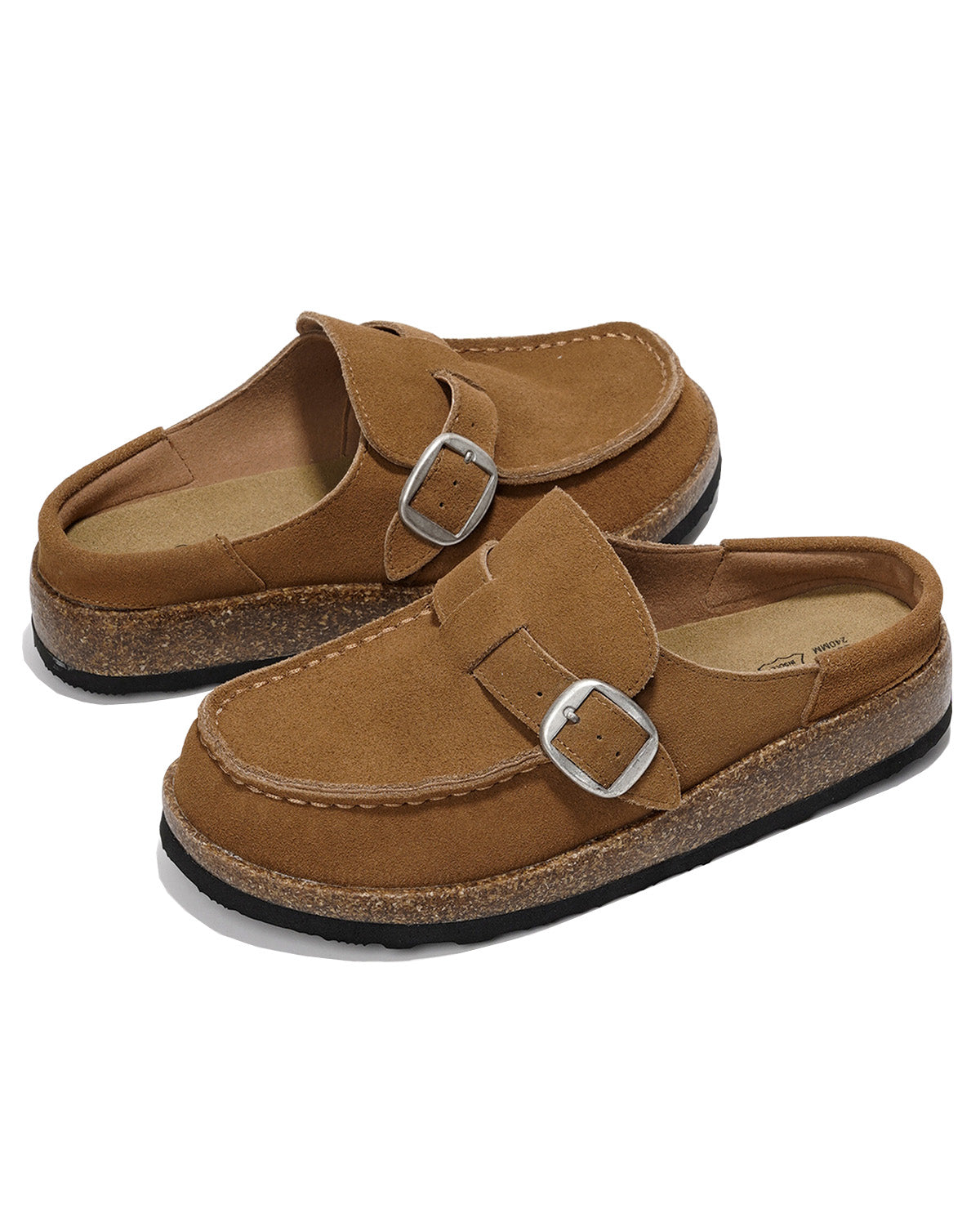 A pair of tan suede slip-on clogs with double silver-tone buckle straps, cork midsoles, and black outsoles, shown on a white background.