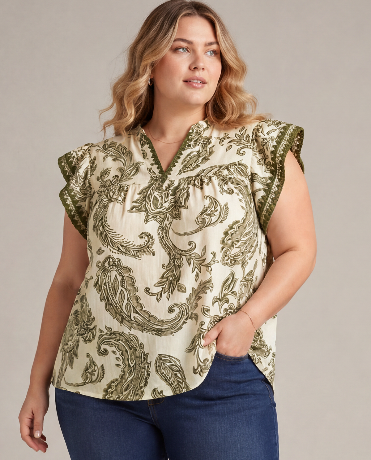 Woman wearing a patterned top with ruffled sleeves against a neutral background